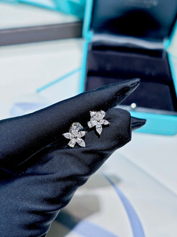 Tiffany Victoria Mixed Cluster diamond earrings held in a black glove