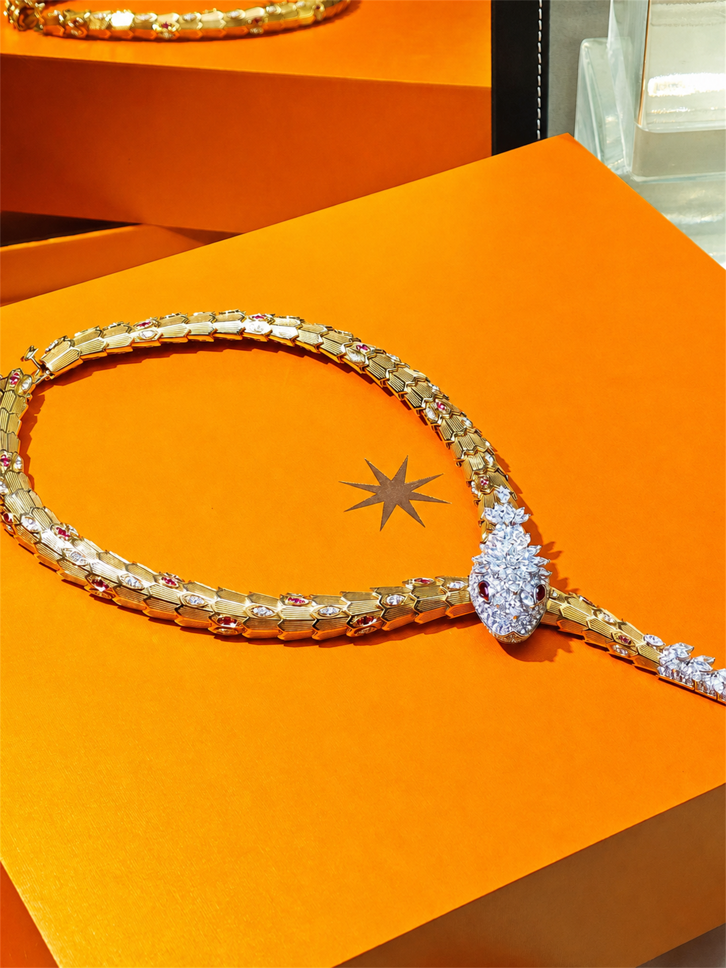 BVLGARI Serpenti high jewelry ruby and diamond lariat necklace, full view on orange presentation case